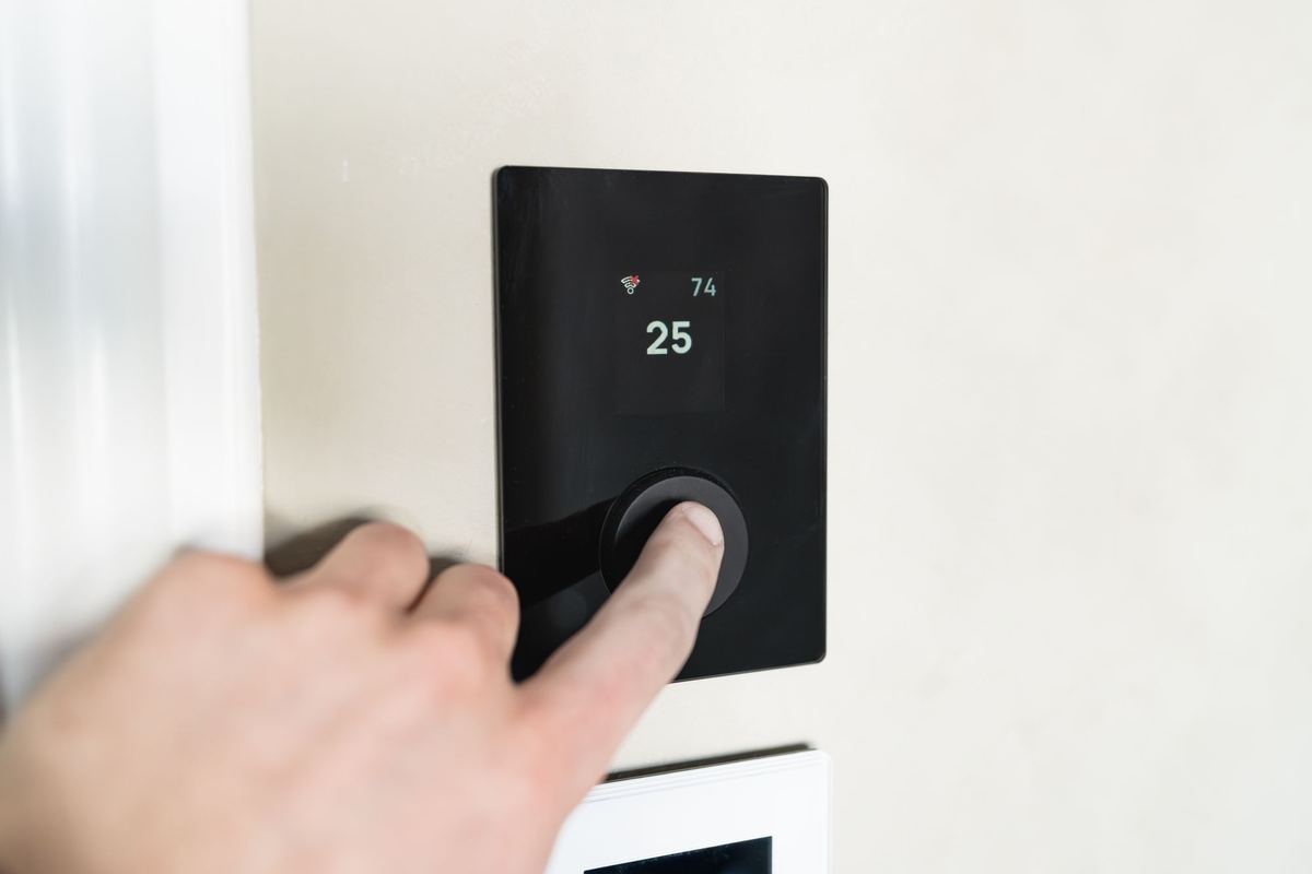 Hand adjusting a smart thermostat