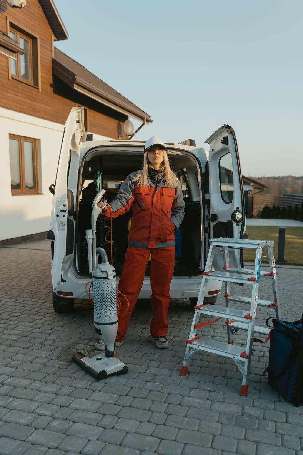 Cleaner unloading supplies from the van outside a home
